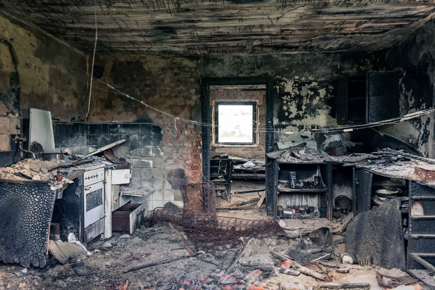 Kitchen destroyed by fire, with charred cabinets and a soot-black ceiling