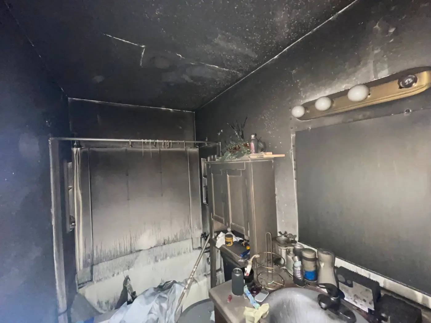 Bathroom walls and fixtures coated in black soot after a house fire